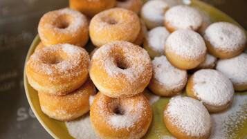 A plate of assorted doughnuts, some coated with sugar.
