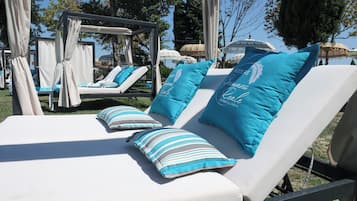 Piscina all'aperto, una piscina a sfioro, lettini