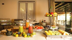Een ontbijtbuffet met diverse soorten fruit, sapjes en ontbijtartikelen.