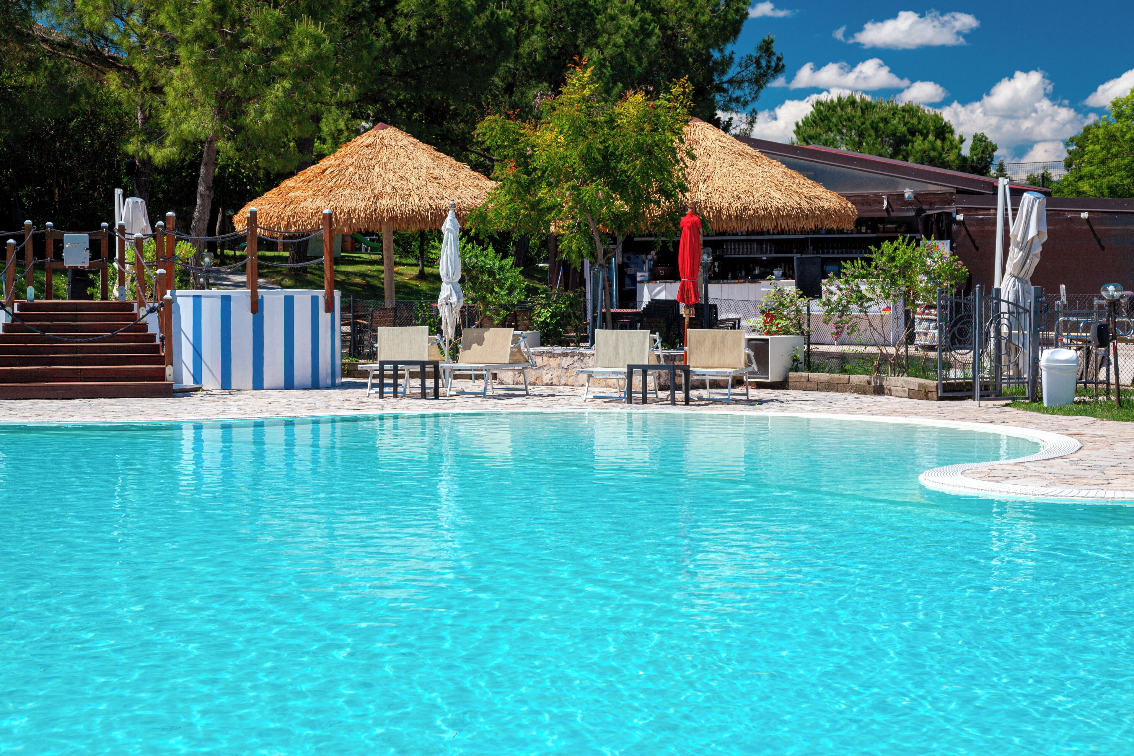 Piscina all'aperto, una piscina a sfioro, lettini