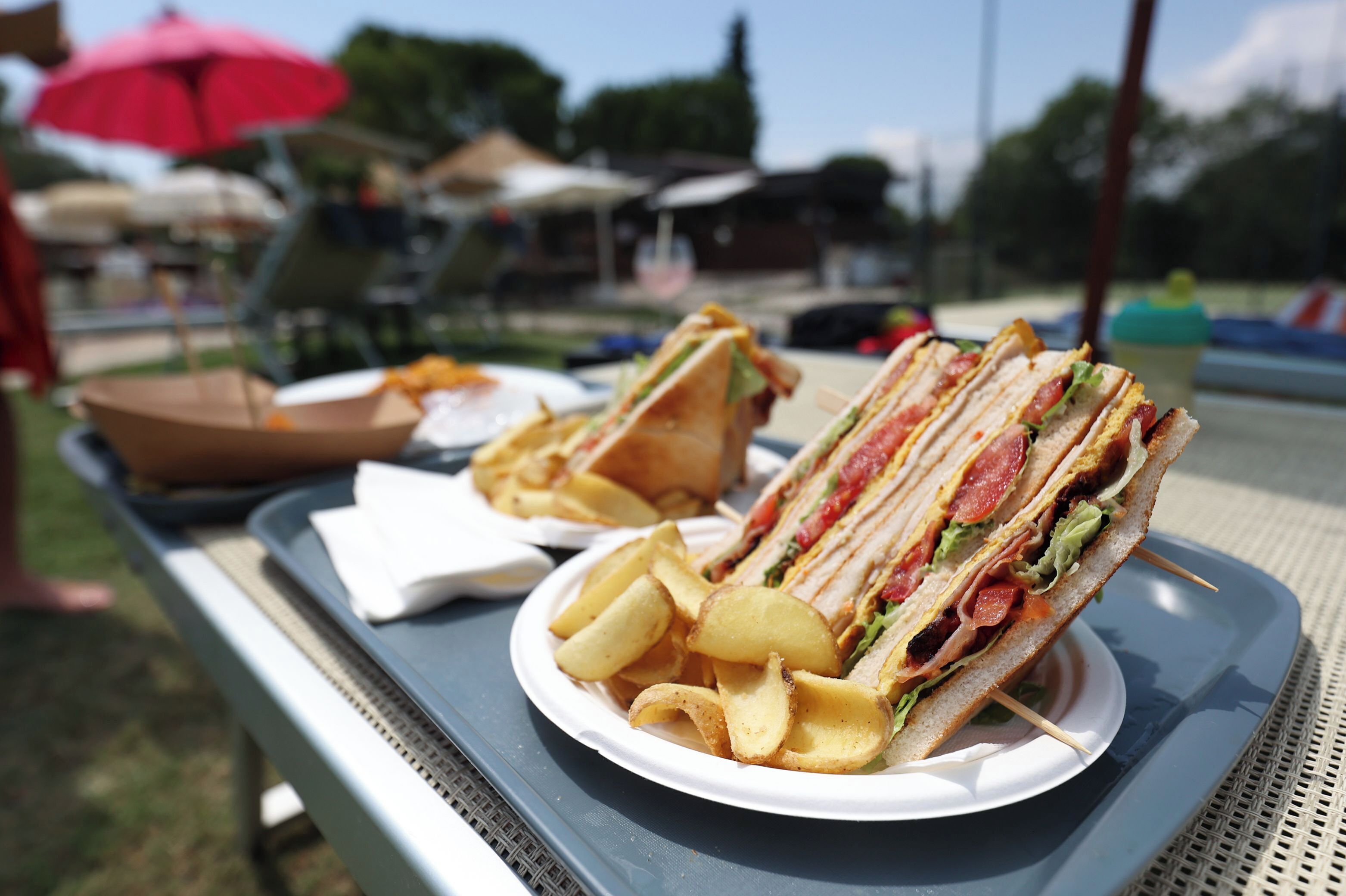 Ein Tablett mit einem Sandwich und Kartoffelchips auf einem Tisch.
