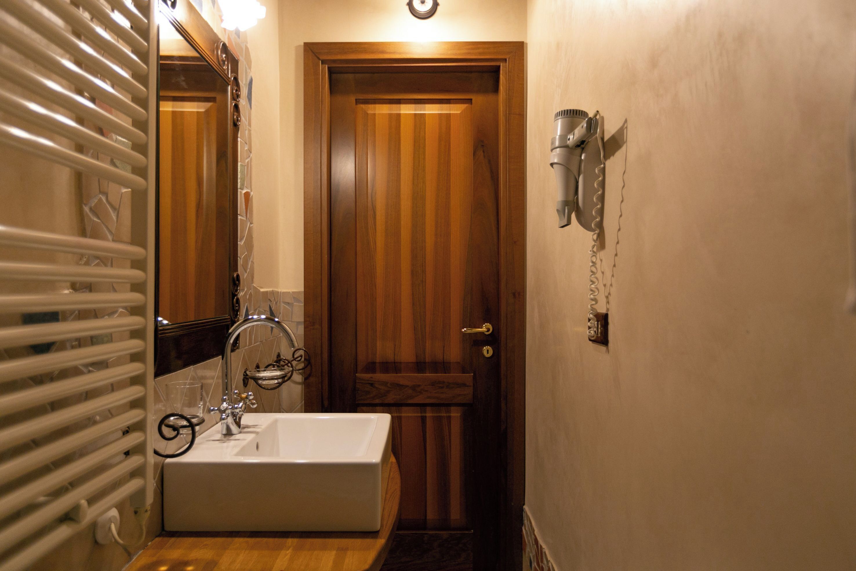 A bathroom with a wooden door, a white sink, and a towel rack.