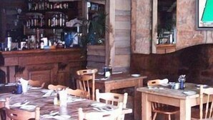 A rustic wooden interior with a bar area, wooden tables, and chairs. - Hotel Roma (Sliema)