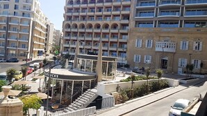 A multi-story hotel with a central atrium, outdoor seating area, and a Starbucks. - Hotel Roma (Sliema)
