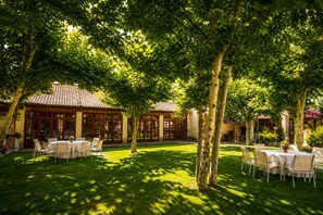 A courtyard with outdoor seating and a building with a tiled roof.