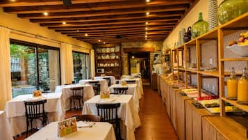 Een restaurant met gedekte tafels, een houten plafond en planken met glaswerk en servies.