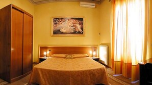 A hotel room with a large bed, a wooden wardrobe, a painting on the wall, and a window with curtains. - La Luna Guesthouse (Florence)