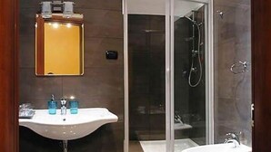 A modern bathroom with a glass-enclosed shower, a sink, and a bidet. - La Luna Guesthouse (Florence)