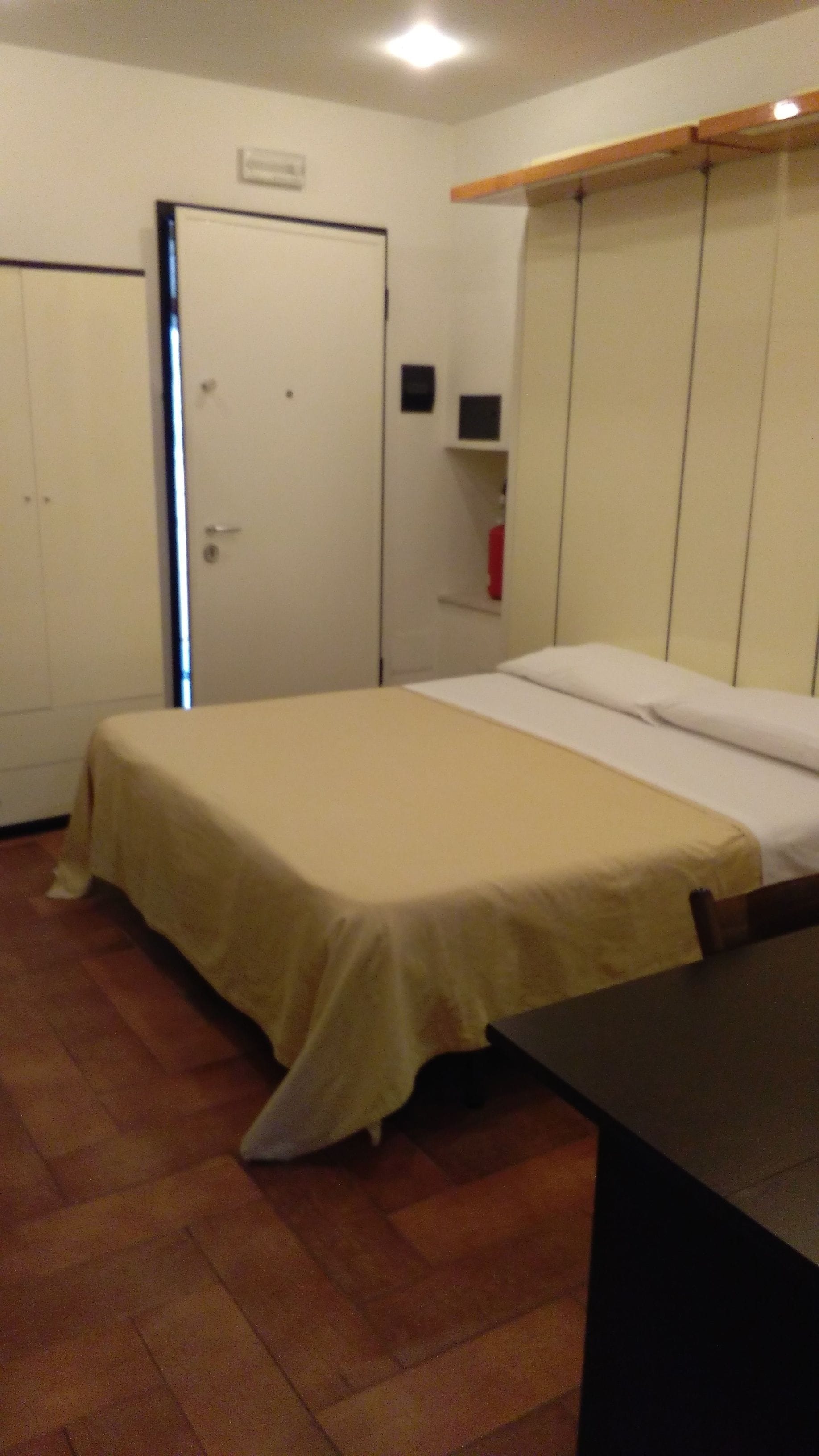 A room with a bed, a wardrobe, and a desk.