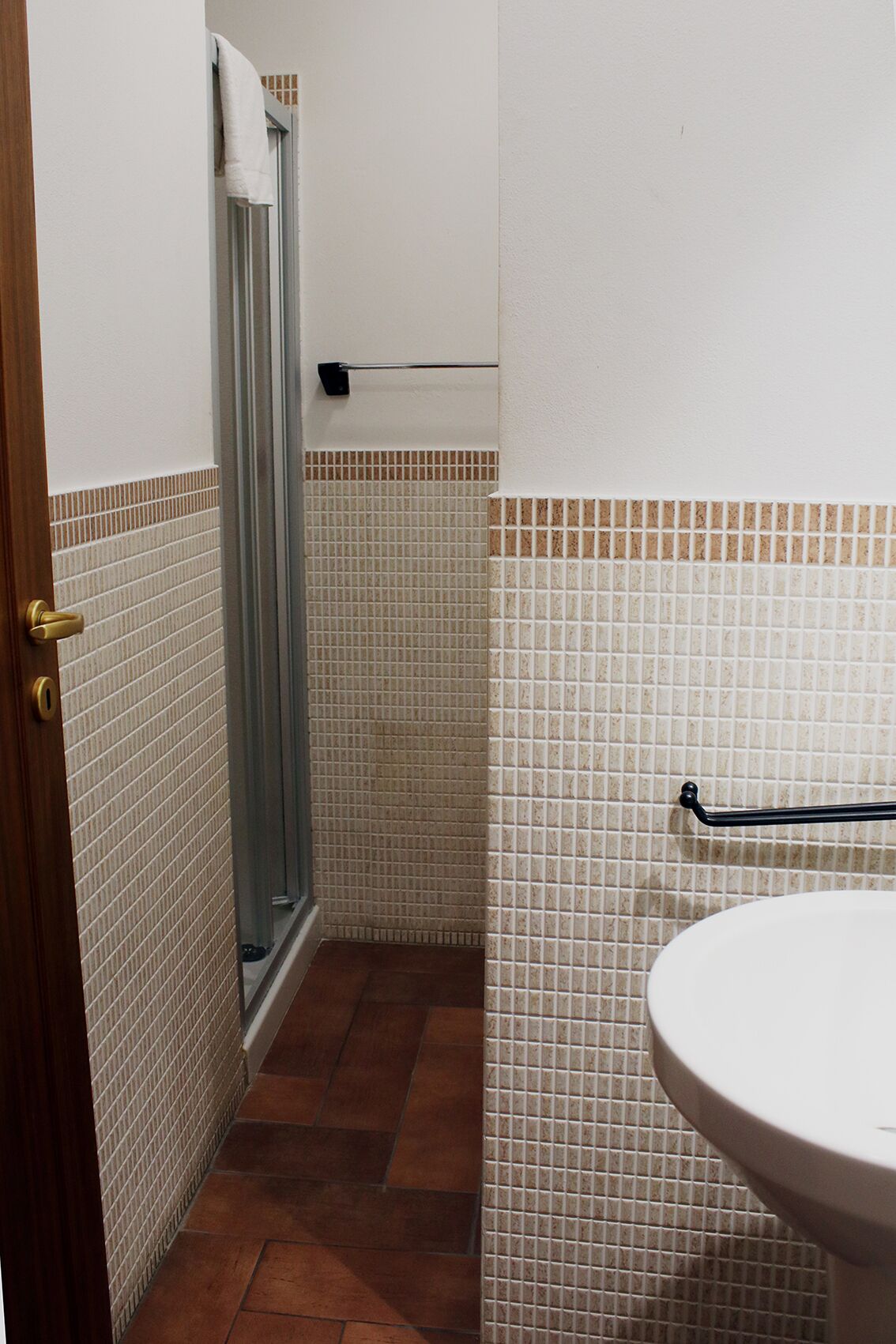 A bathroom with a shower, a toilet, and a sink.