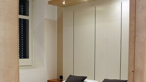 A bedroom with a bed, pillows, and neatly folded towels. - Residence Arco Antico (Syracuse)