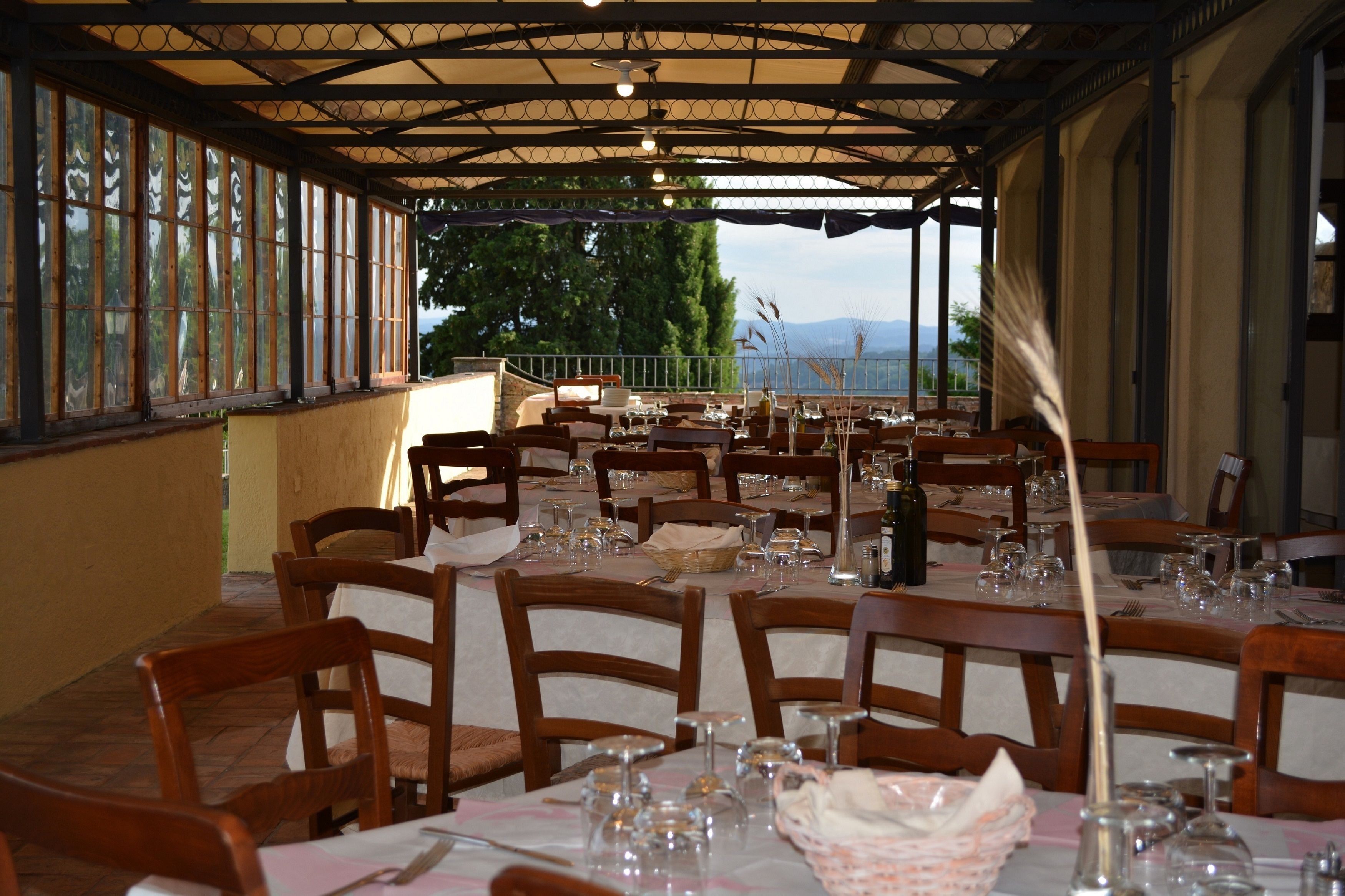 A restaurant with multiple tables set for dining, featuring a view of the outdoors.