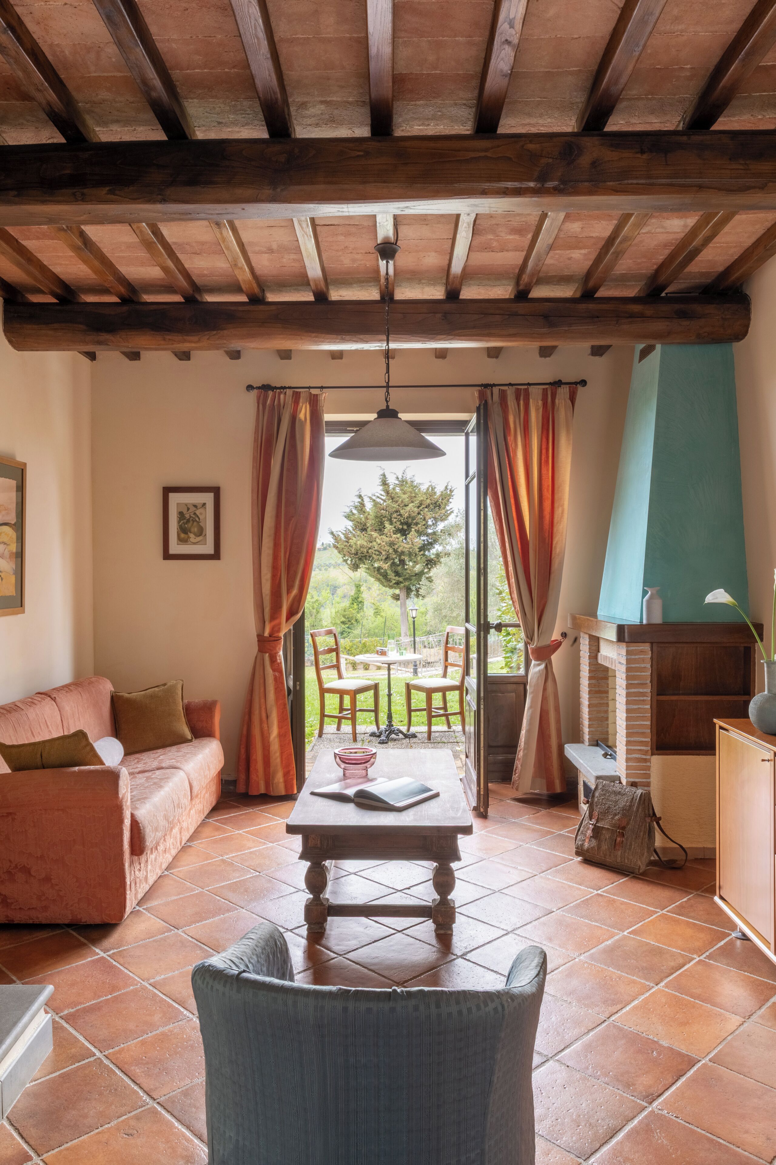Una sala de estar acogedora con techo de madera, un sofá, una mesa y vistas al exterior.