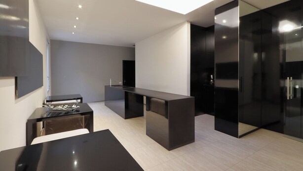 A modern kitchen with a central island, dark cabinetry, and a skylight. - Muà Boutique Bologna (Bologna)