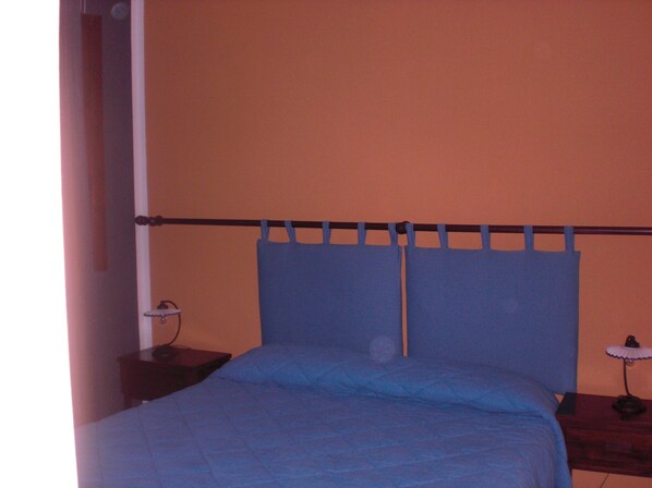 A bedroom with a bed, a nightstand, and a lamp. - A Giummara (Marsala)