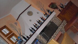 A bar area with bottles of wine and a wicker chair. - A Giummara (Marsala)