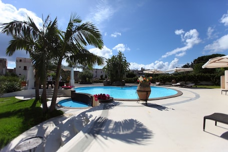 Una piscina al aire libre de temporada, sombrillas