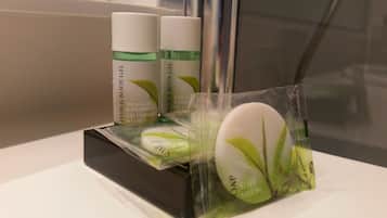 A bathroom counter with a black soap dish holding a bar of soap and a package of shampoo.