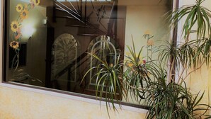 A window with a view of a staircase and a plant.