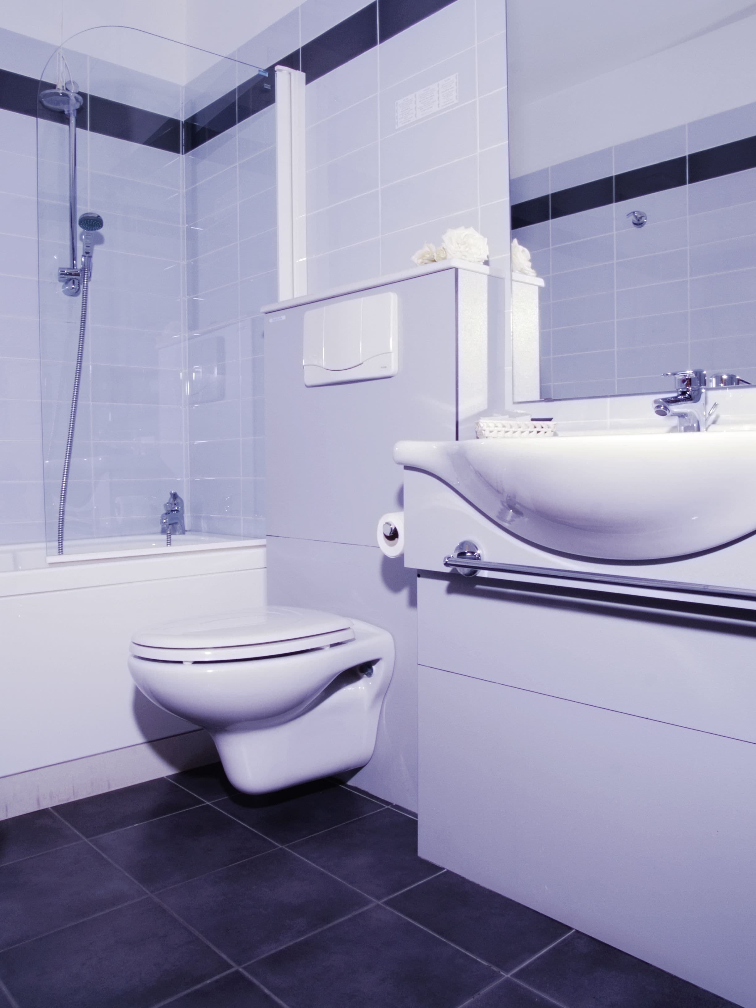 A modern bathroom with a white toilet, a sink, and a shower.
