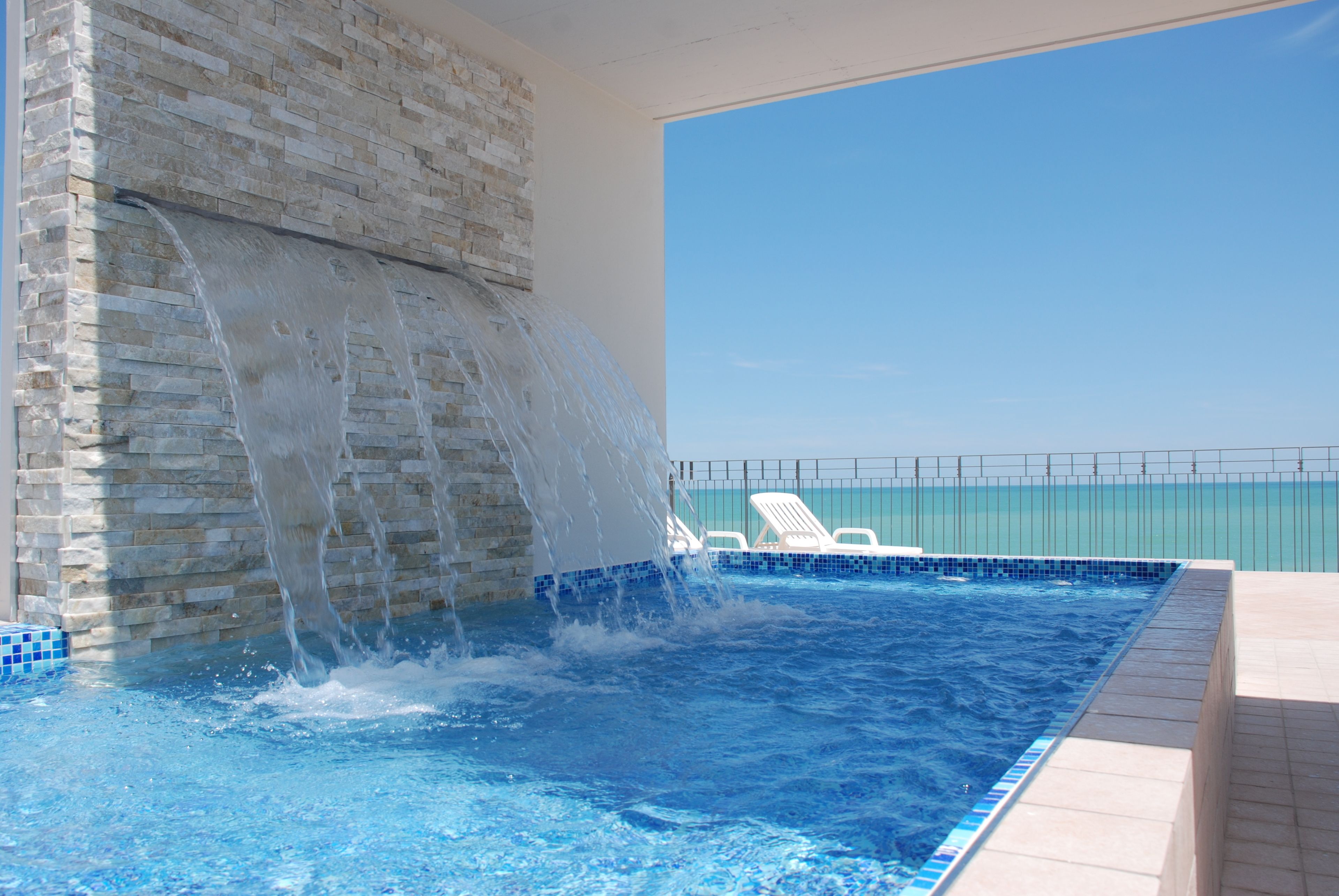 Una piscina al aire libre de temporada, sillones reclinables de piscina