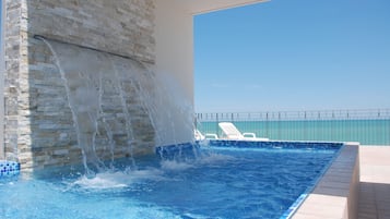 Una piscina al aire libre de temporada, sillones reclinables de piscina