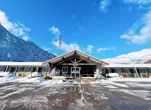A hotel with a covered entrance, a mountain backdrop, and a clear sky. - Fasthôtel Thônes (Thones)