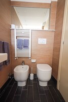 Kylpyhuoneessa on kaksi wc-istuinta, bidee, pyyhekoukku pyyhkeineen, peili ja wc-paperiteline.