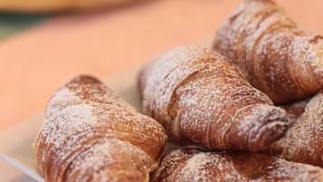 Un plato de croissants espolvoreados con azúcar glas.