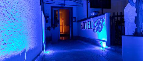 A hallway with a sign reading "HOTEL B" and a potted plant.