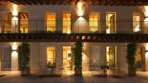 A hotel with a covered outdoor seating area, multiple balconies, and potted plants. - Albergo Al Moretto (Castelfranco Veneto)
