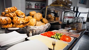 A buffet with various food items including pastries, bread, and fresh vegetables. - City BackPackers Hostel (Stockholm)