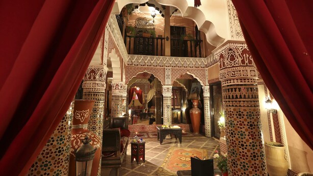 An ornate interior with a balcony, patterned walls, and traditional furnishings. - Riad Mille et une Nuits (Marrakech)