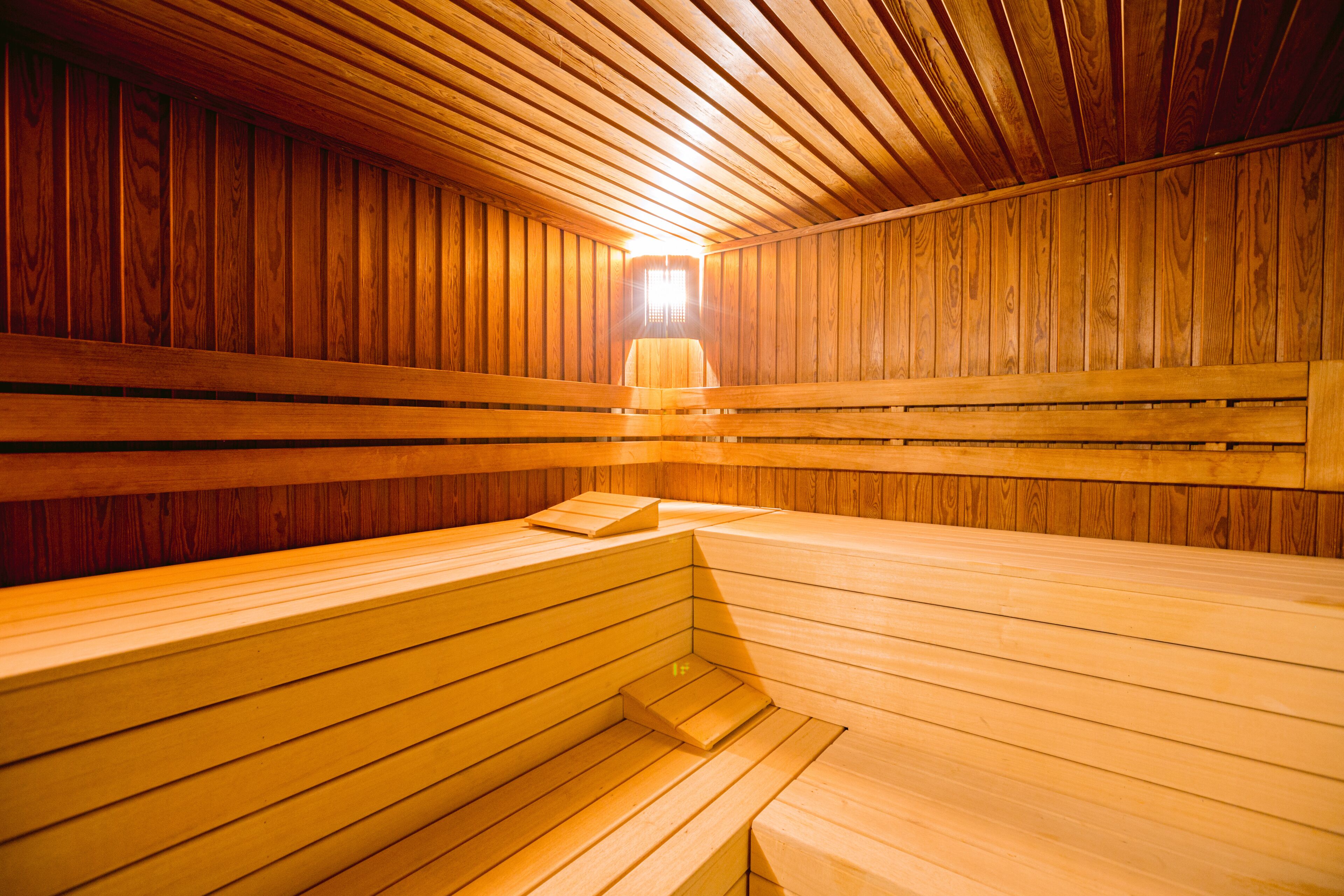 A sauna with wooden benches and a sloped ceiling.
