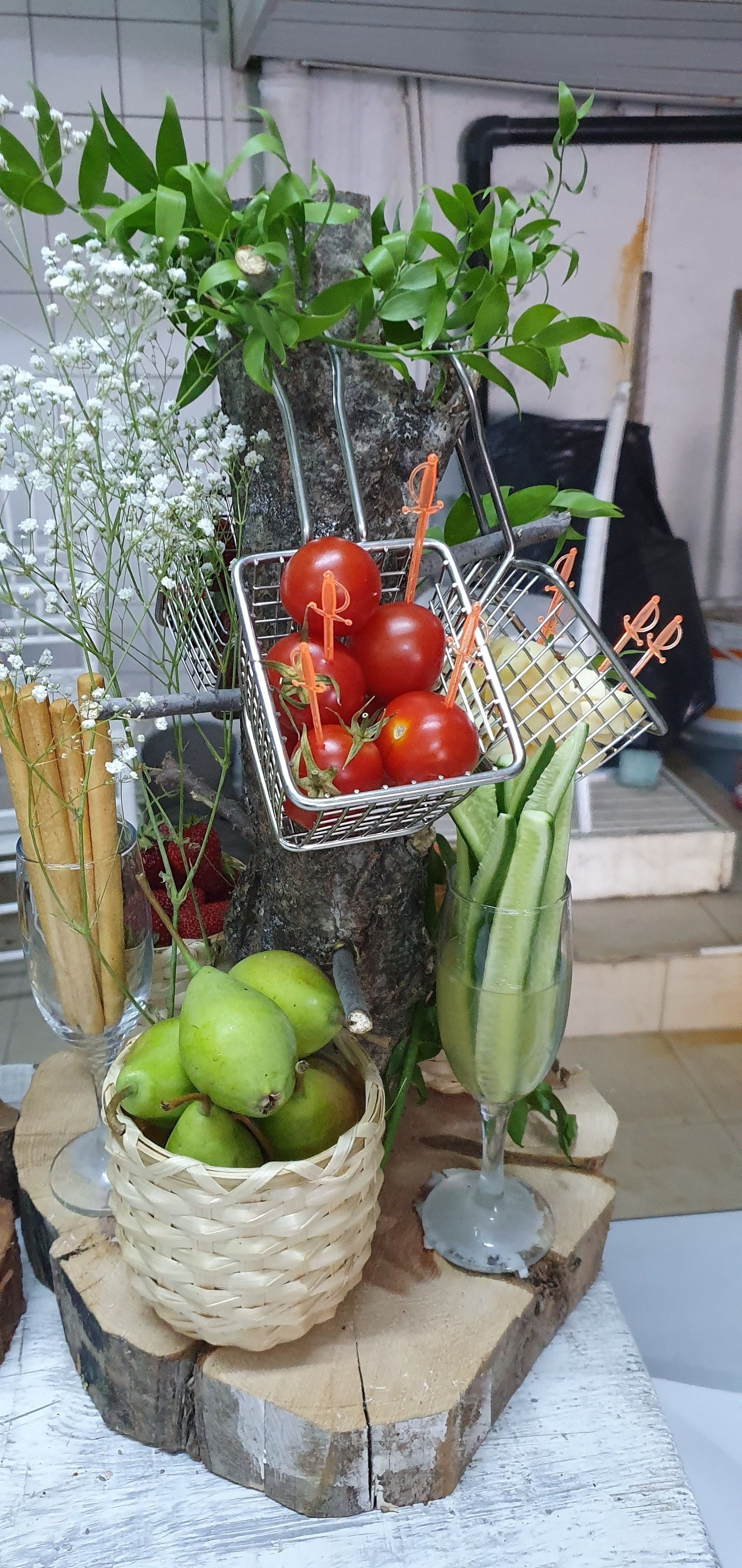 Presentación de productos frescos como tomates, peras y hierbas, dispuestas sobre una superficie de madera con un fondo rústico.