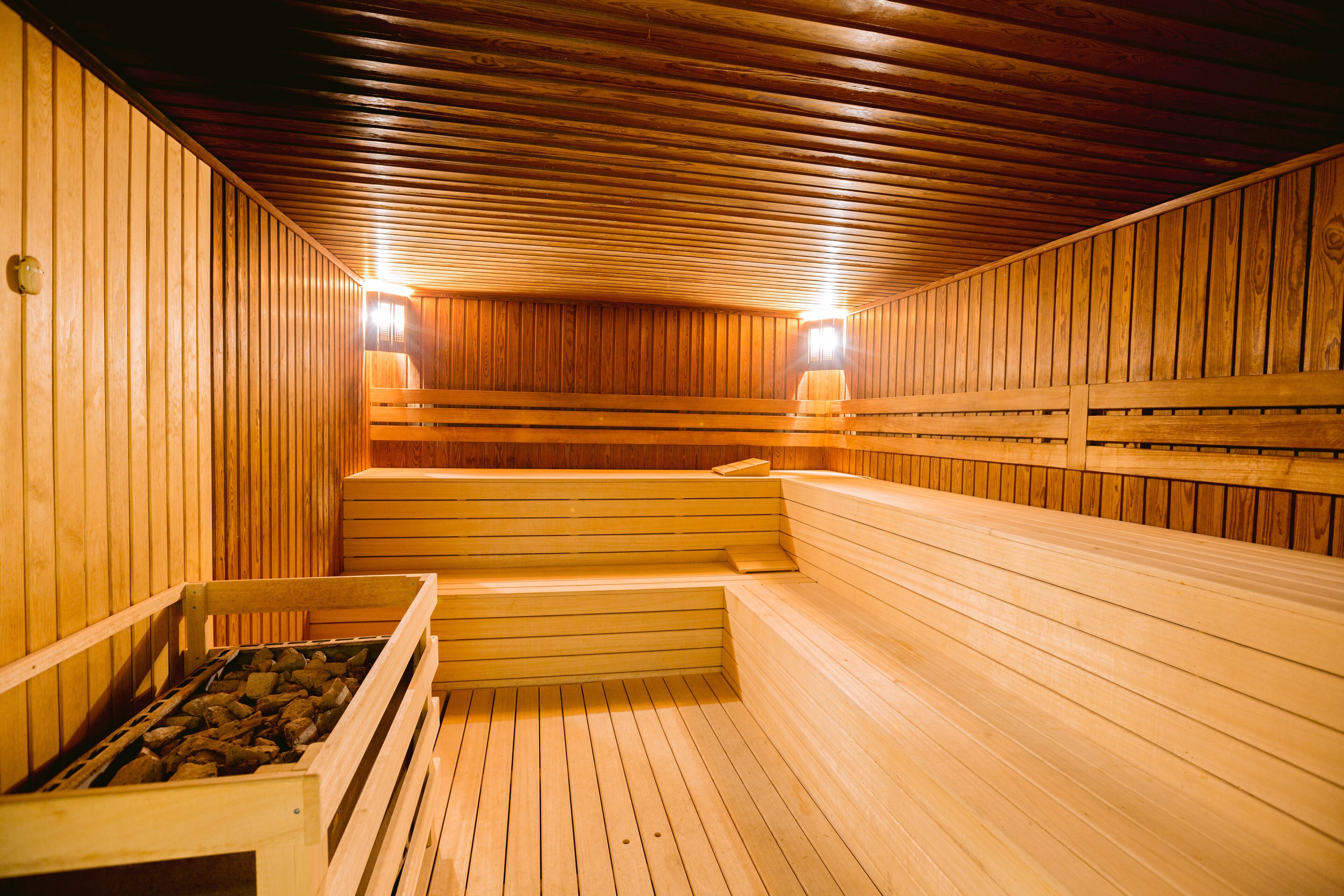 Uma sauna com bancos de madeira e um banco de pedra.