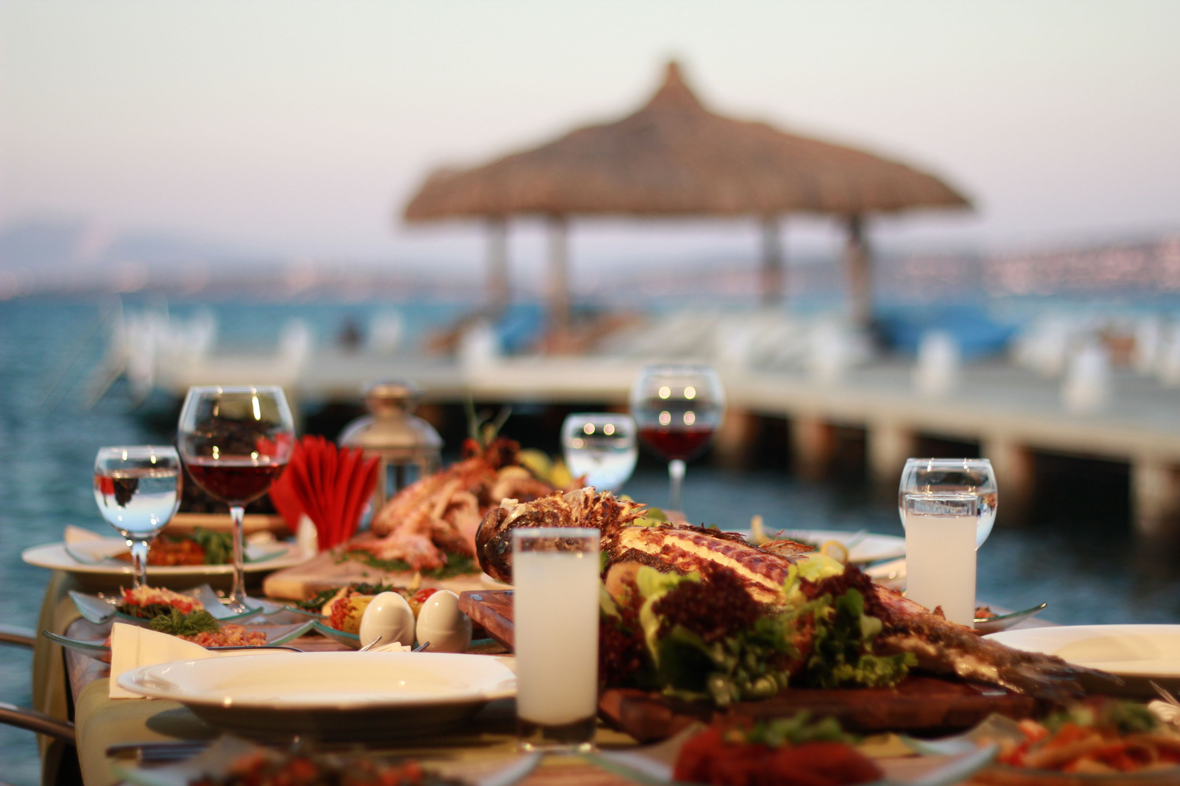 A dining table with plates, glasses, and a large fish centerpiece.