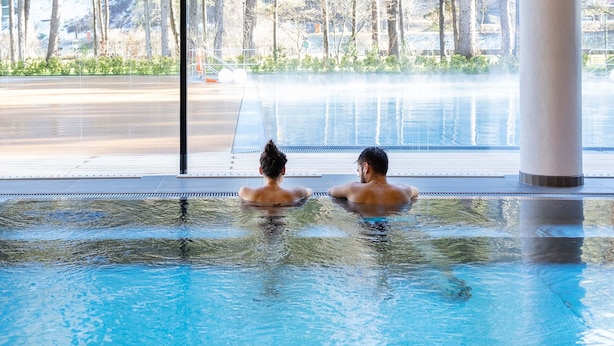 An indoor swimming pool with clear views of a forested area outside. - Grand Hotel Terme di Comano (Stenico)