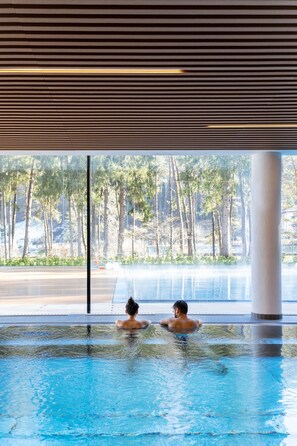 An indoor swimming pool with clear views of a forested area outside. - Grand Hotel Terme di Comano (Stenico)