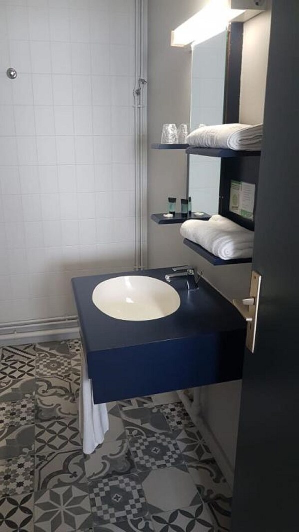 A bathroom with a white sink, dark blue countertop, and patterned floor tiles. - L'Orée du Bois (Font-Romeu-Odeillo-Via)