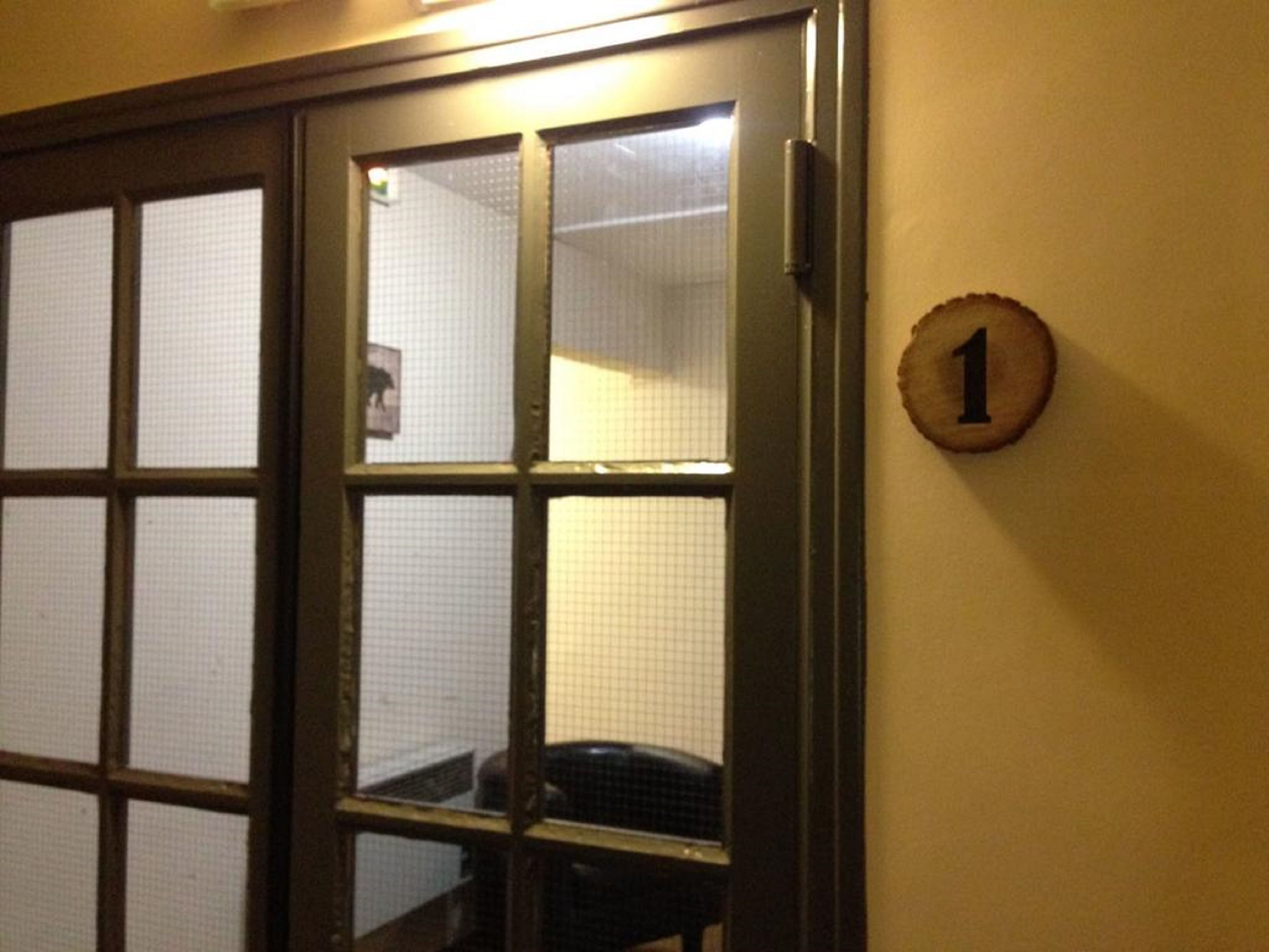 A door with a grid pattern and a number '1' sign on the wall.