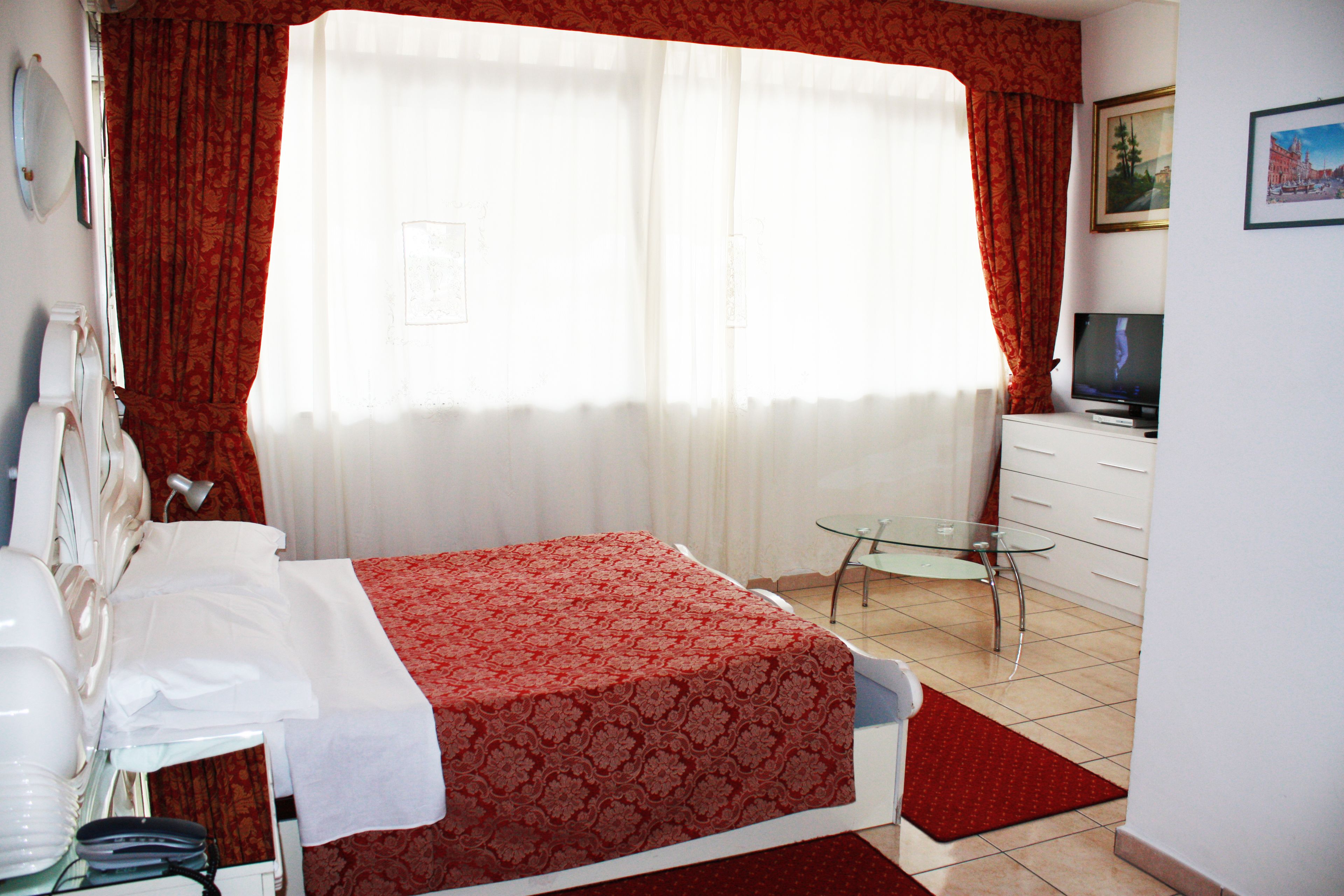 Une chambre d’hôtel comprenant un lit, une table en verre, un téléviseur et une salle de bain.