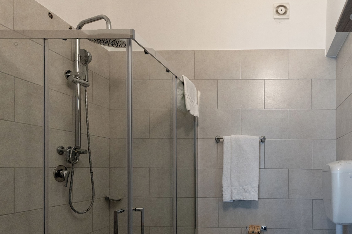 Un baño moderno con ducha de vidrio, inodoro y lavamanos.