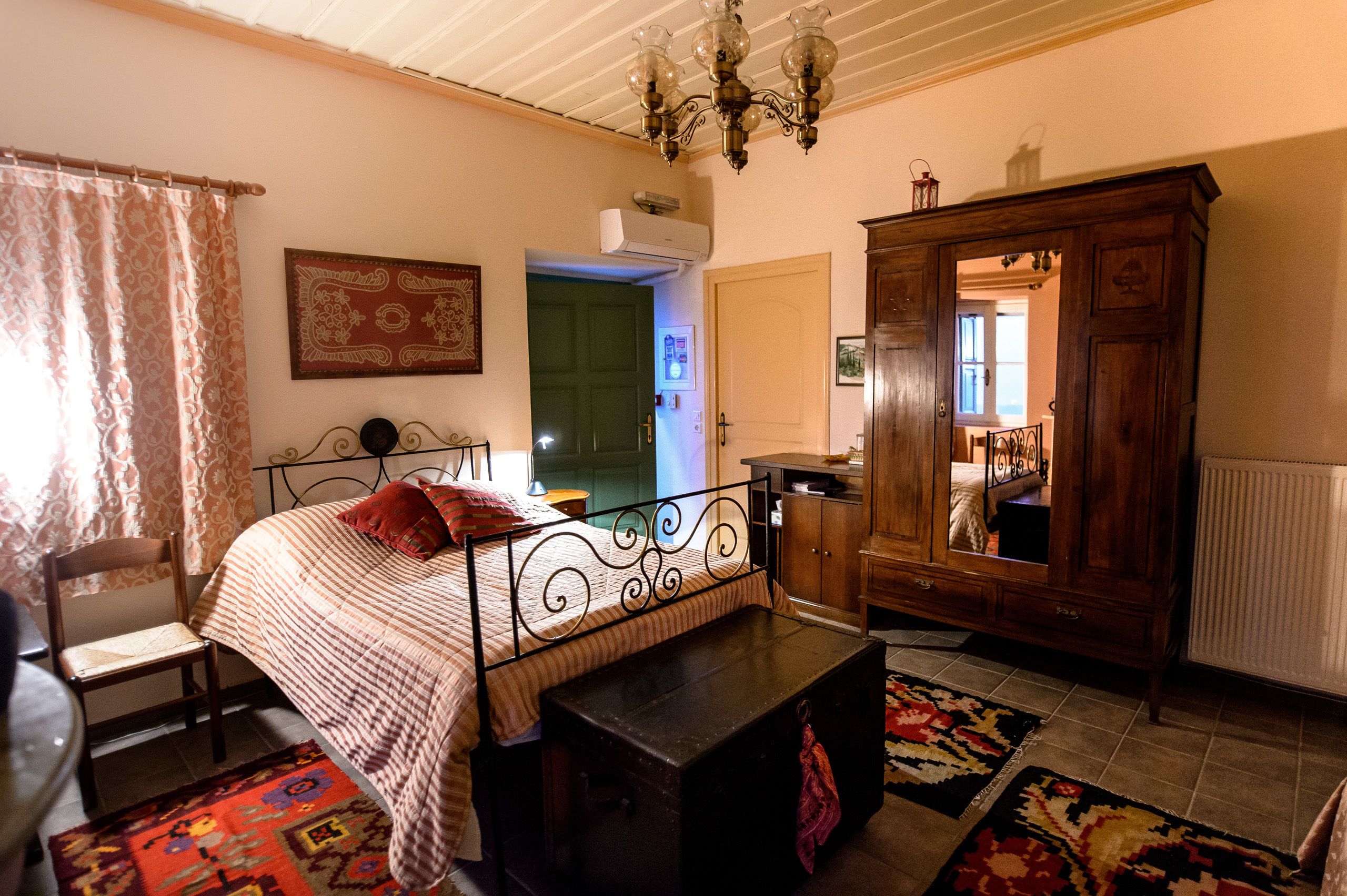 Un dormitorio con una cama, un armario de madera, un escritorio y una silla.