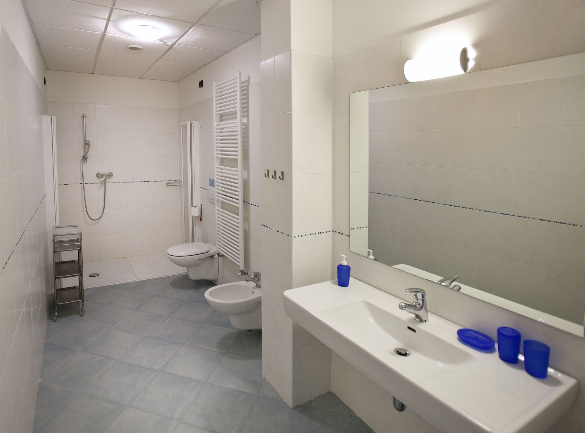 A bathroom with a shower, toilet, and sink.