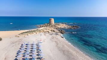 En la playa, sillas reclinables de playa, sombrillas