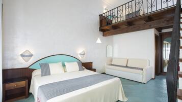 Ein Schlafzimmer mit Bett, Nachttischen, einer Couch und einem Balkon mit Geländer.