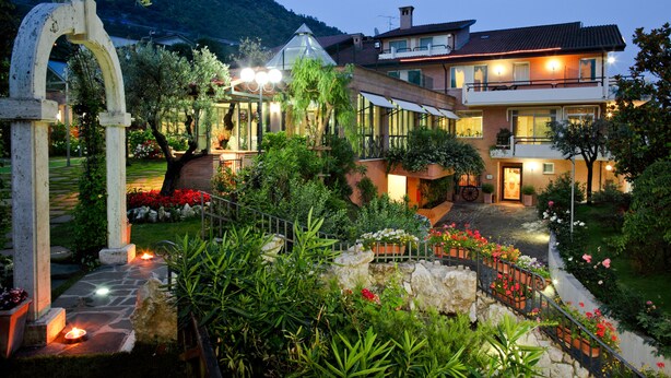 A two-story house with a garden, a stone archway, and a well-lit entrance. - Hotel Des Reves - Al Poggio di Casalucense (Sant'Elia Fiumerapido)