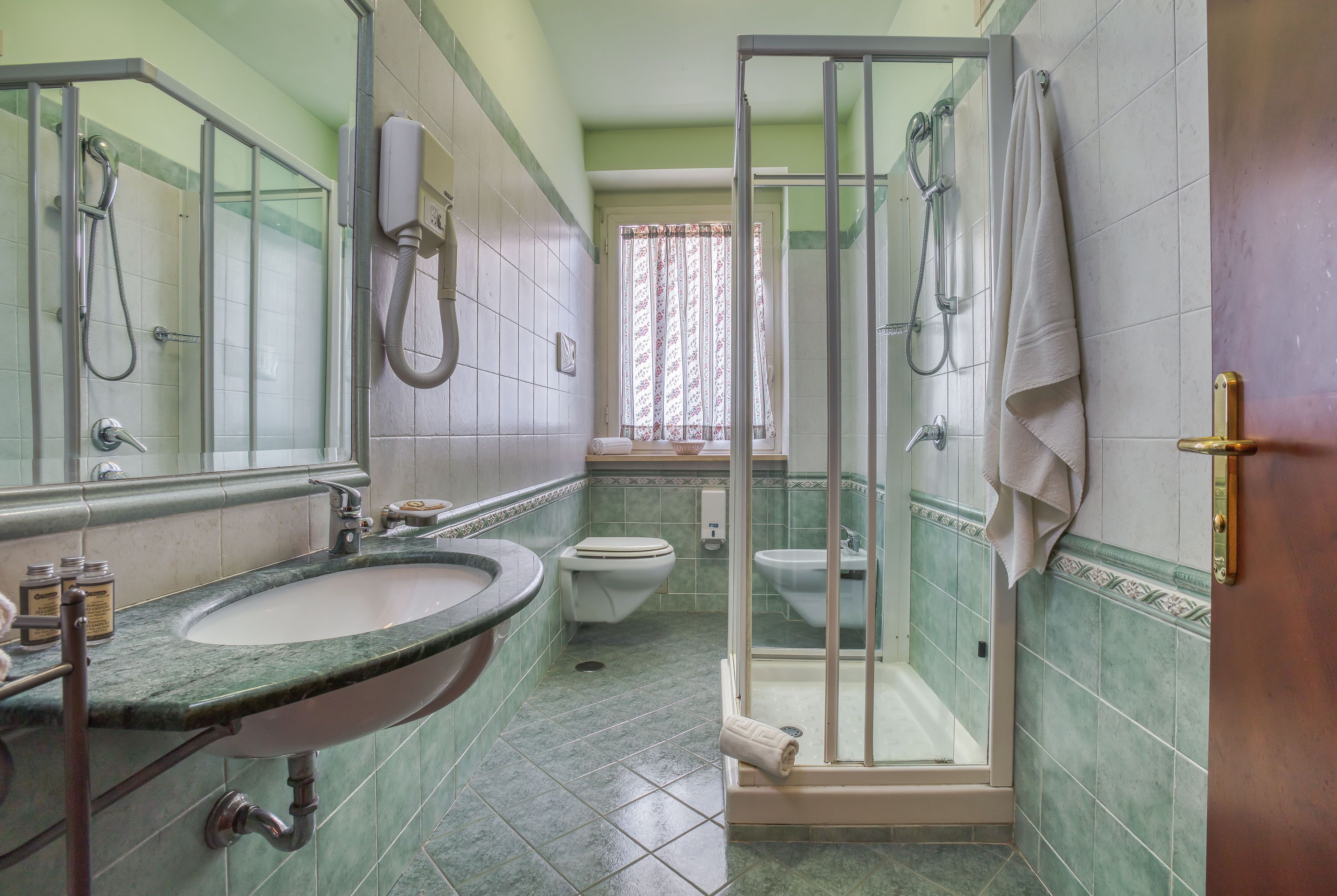 A bathroom with a sink, toilet, and shower area.