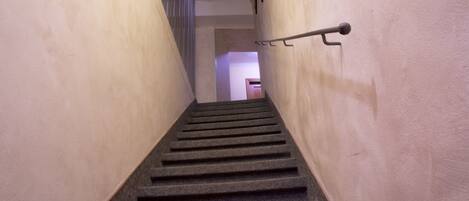 Una escalera con barandilla y una puerta al final.